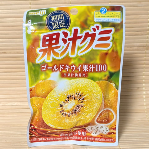 A pack of Meiji Kaju Gummy candy containing Golden Kiwi flavor. Colorful pack with an image of a cut kiwi on the face. Displayed on a tatami surface.