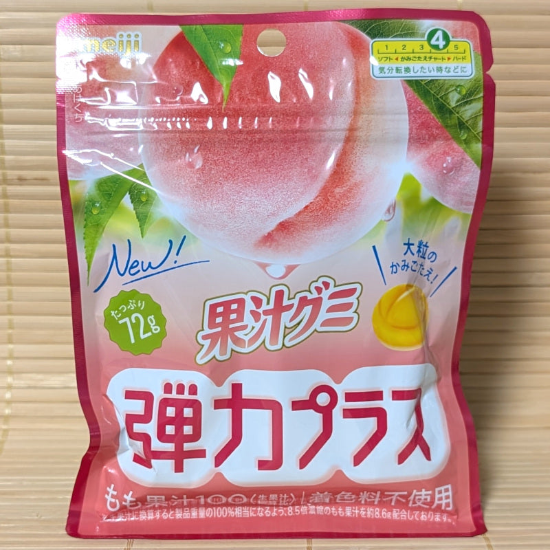 Pouch of Kaju Peach Hard Gummies by Meiji with Japanese text. Displayed on a wooden surface