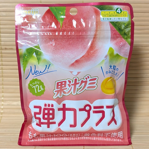Pouch of Kaju Peach Hard Gummies by Meiji with Japanese text. Displayed on a wooden surface