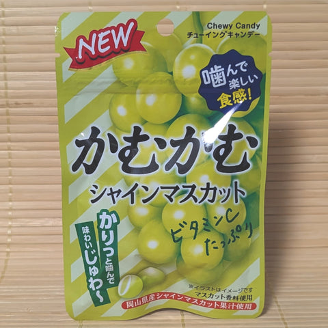 A green 30g pouch of Kamu Kamu Shine Muscat Chewy Candy with new packaging layout featuring a bunch of green grapes on a bamboo mat.