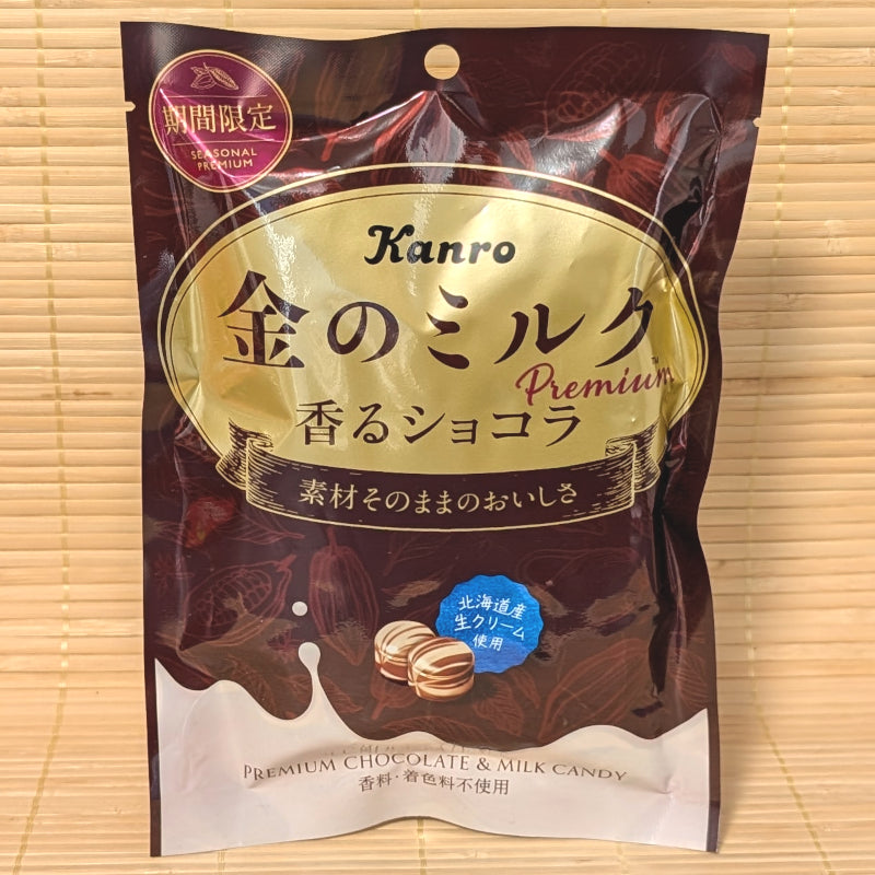 A luxurious gold and chocolate-colored pouch of Kanro Kin no Milk Fragrant Chocolate candy featuring marbled candy pieces and a splash of milk.