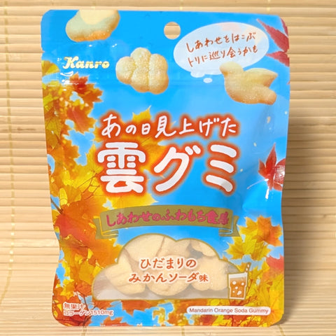 A Kanro mandarin orange cloud gummy candy package with autumn leaf design on a wooden surface