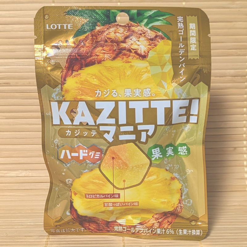 A metallic gold 49g pouch of Lotte Kazitte Mania Golden Pineapple gummies showing pineapple slice graphics on a bamboo mat.