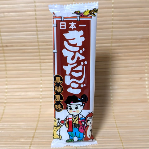 Japanese Kibi Dango Kokuto  dagashi candy package with cartoon Momotaro character all displayed on a tatami surface.