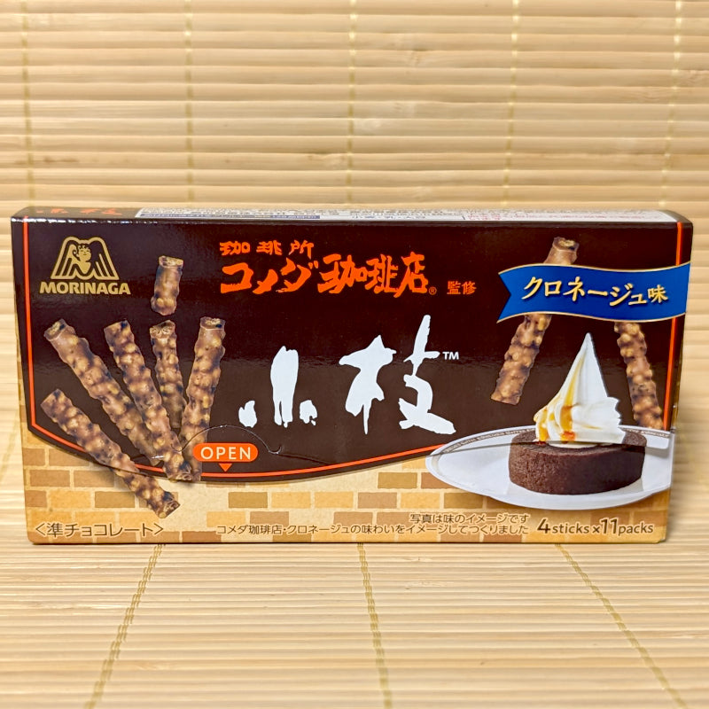 A brown box of Morinaga Koeda chocolate sticks featuring the Komeda's Coffee logo and an image of the Kuro-Neige dessert.