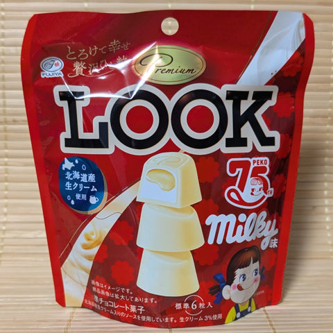 A Fujiya Premium LOOK chocolate collaboration with Milky that has a rich condensed white milk flavor. Displayed on a wooden surface