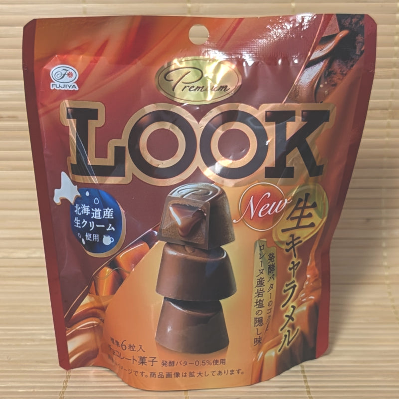 A 45g standing pouch of Fujiya LOOK Premium Fresh Caramel chocolates with Hokkaido cream, resting on a bamboo mat.