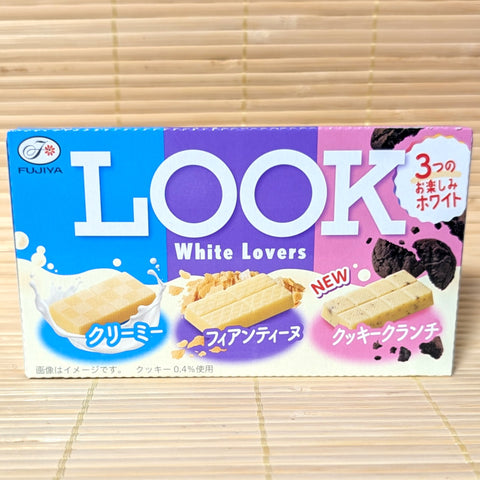 A box of Look White Lovers cookies, containing 3 varieties, with colorful design. Displayed on a tatami surface.
