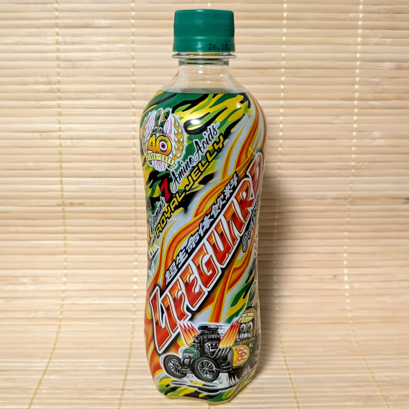 A 500ml plastic bottle of Cheerio Lifeguard soda featuring orange flames, green camo graphics, hot rod artwork, and a 40th Anniversary 1986-2026 logo on a bamboo mat background.