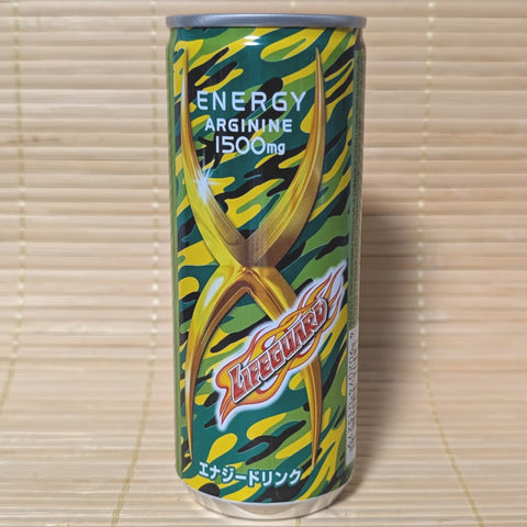 A green and yellow camouflage slim can of Lifeguard Energy Soda with a large gold X and 1500mg Arginine label. Displayed on a tatami background.