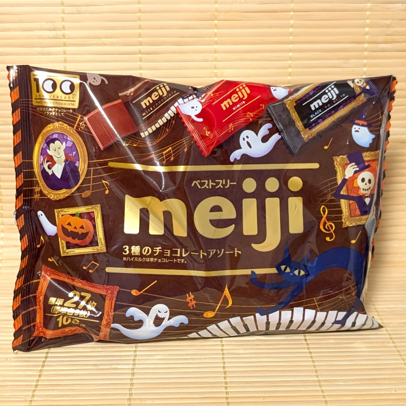 A 108g bag of Meiji Best Three Halloween Chocolate Assortment displaying ghosts, vampire artwork, and 3 chocolate varieties on a bamboo mat.