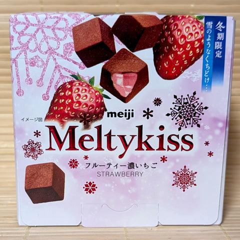 A pink and white 53g box of Meiji Meltykiss Fruity Strawberry Chocolate showing fresh strawberries and cocoa-dusted cubes on a bamboo background.   