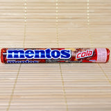 A single roll of Mentos Cola chewy candy featuring a deep red and brown wrapper with the classic blue Mentos logo, displayed horizontally on a tatami mat background.