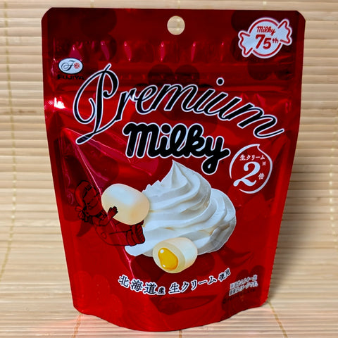 A metallic red pouch of Fujiya Premium Milky candy featuring a swirl of fresh cream and the iconic Peko-chan character.