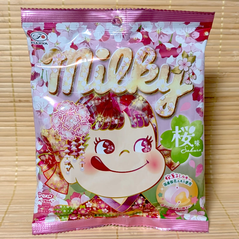 A pink bag of Fujiya Milky Sakura candy featuring Peko-chan in a kimono displayed on a traditional tatami background.