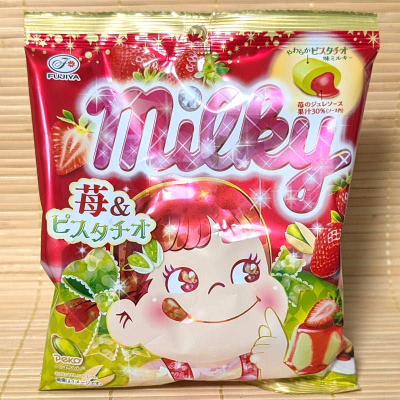 Colorful packaging of Milky Strawberry and Pistachio flavored candy with the Peko chan cartoon character. Displayed on a wooden surface