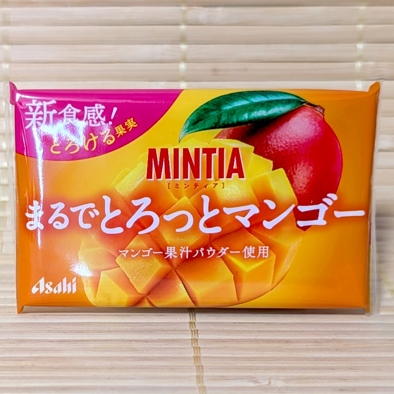 A bright orange and pink Asahi Mintia Marude Torotto Mango case showing diced mango fruit graphics on a bamboo mat.