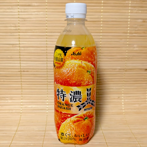 A 500ml plastic PET bottle of Asahi Mitsuya Tokunou Orange Squash with a vibrant orange label showing fresh citrus fruits, on a tatami background.