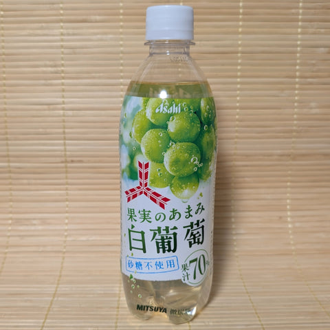 A 500ml clear plastic bottle of Asahi Mitsuya White Grape Soda showing lush green grape clusters and a 70% juice logo on a tatami background.