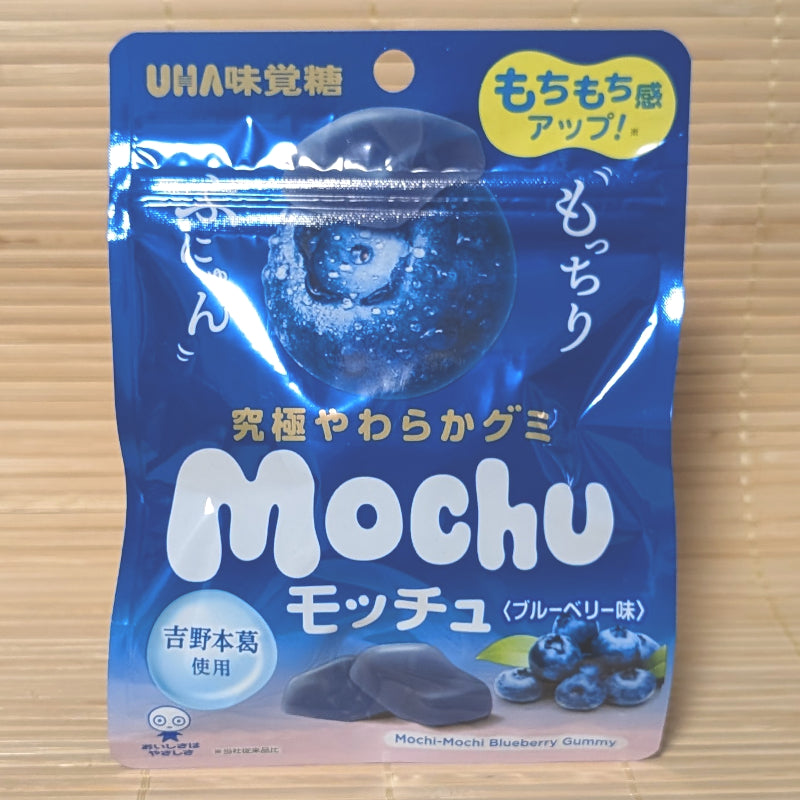 A vibrant blue 45g pouch of UHA Mochu Blueberry soft gummies showing fresh blueberries on a bamboo mat background.