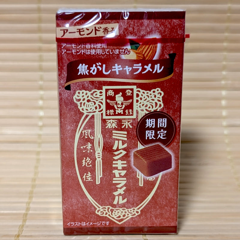 A deep red pocket box of limited edition Morinaga roasted almond milk caramel candies showing retro typography on a tatami background.