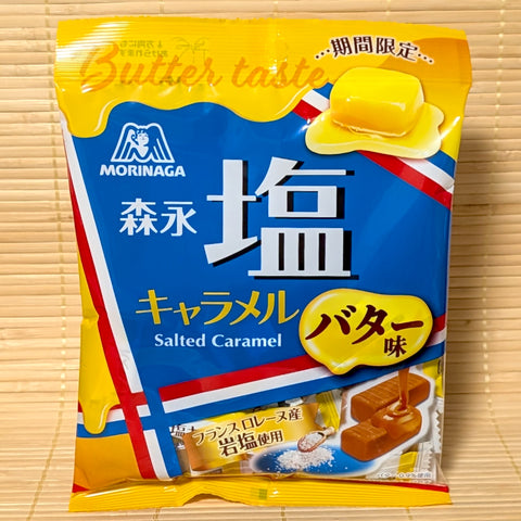 A bright yellow 69g bag of Morinaga Salted Caramel Butter Taste showing French salt and caramel graphics on a bamboo background.   