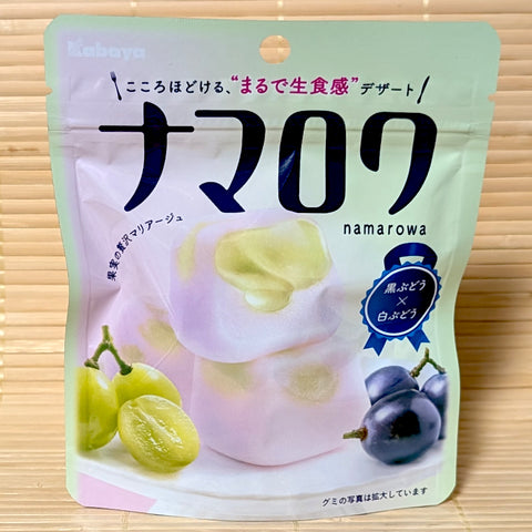 A pastel green pouch of Kabaya Namarowa Gummy Dark Grape & White Grape with fresh grape illustrations on a bamboo mat background.