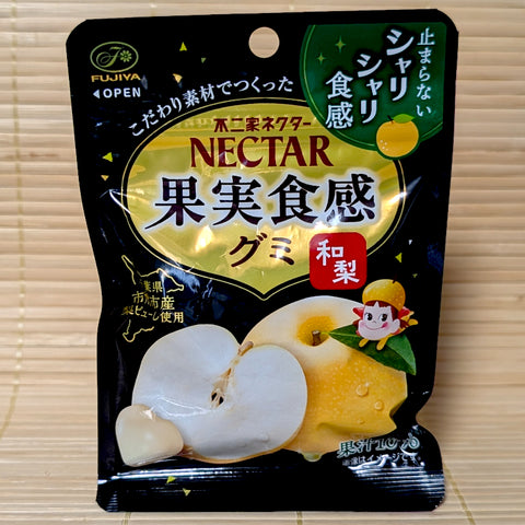 A black 48g resealable pouch of Fujiya Nectar Japanese Pear gummies showing sliced Asian pear artwork and Peko-chan mascot on a bamboo mat background.