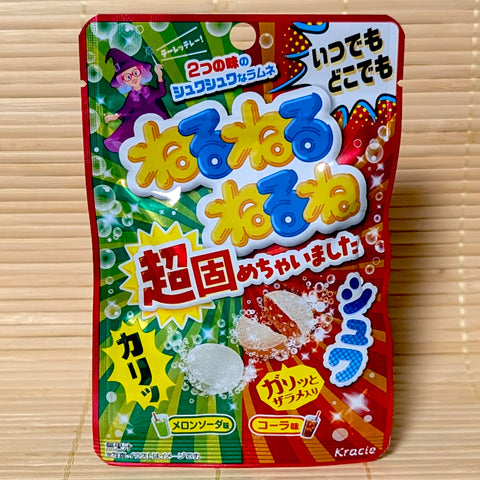 A bright red and green 21g pouch of Kracie Neru Neru Nerune Fizzy Candy Tablets showing the witch mascot and soda graphics on a bamboo background.