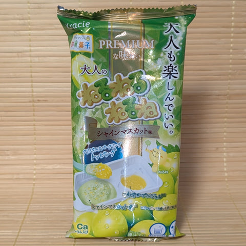 A green and gold 21g package of Kracie Premium Otona no Neru Neru Ne Shine Muscat DIY candy kit on a bamboo mat.