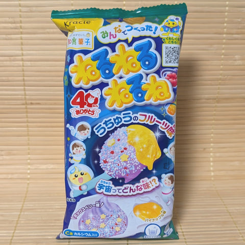 A blue and green space-themed pouch of Kracie NeruNeruNeruNe Space Fruit DIY candy kit displayed on a tatami background.