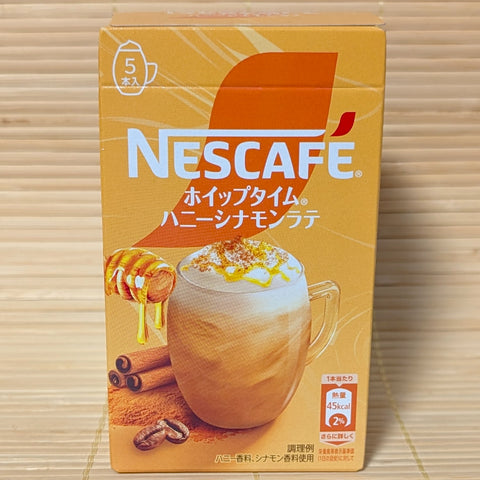 Gold box of Nescafe Whip Time Honey Cinnamon Latte instant coffee sticks with honey dipper and cinnamon sticks.