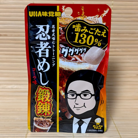A slim red and black pouch of Ninja Meshi Extra Tough Cola gummies on a tatami background, featuring a ninja character and 130% toughness callout.
