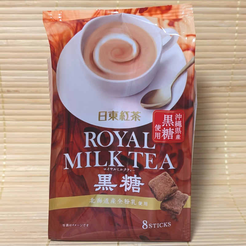 A warm brown bag of Nittoh Royal Milk Tea Kokuto featuring a swirling cup of tea and Okinawan brown sugar cubes. Displayed on a tatami surface.