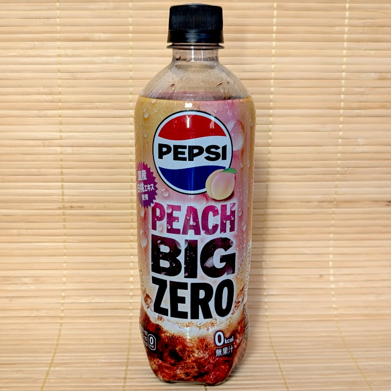 A 600ml clear plastic bottle of Pepsi Japan Peach Big Zero Cola featuring white peach graphics and a bold label on a bamboo mat background.