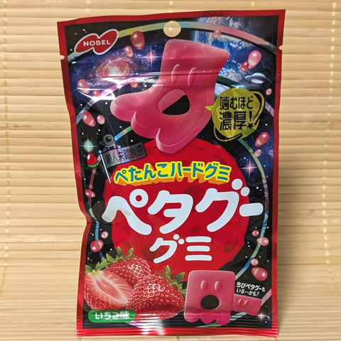 A cosmic space-themed red pouch of Petagu Strawberry Hard Gummy showing flat pink character gummies on a bamboo background.   