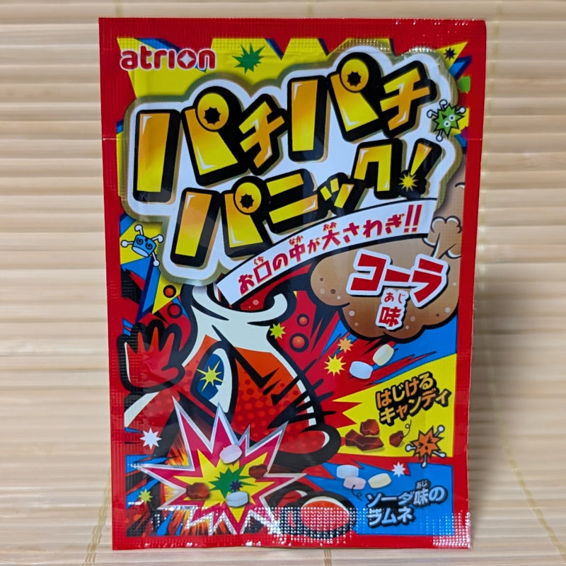A pack of cola flavored popping candy (pop rocks) by Atrion Japan, a subsidiary of Meiji confectionery. Displayed on a tatami background.