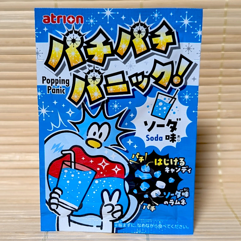 Atrion Popping Panic Ramune Soda candy packaging with a cartoon character, displayed on a wooden surface