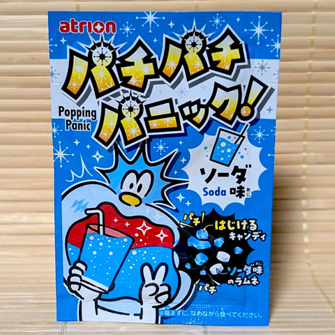 Atrion Popping Panic Ramune Soda candy packaging with a cartoon character, displayed on a wooden surface