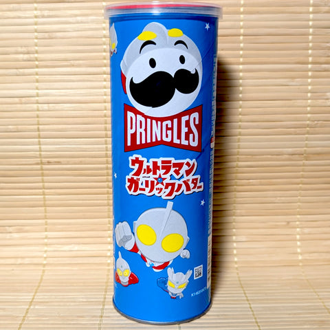 A tall blue 95g can of Japanese Pringles Garlic Butter potato chips featuring a superhero-styled mascot and Ultraman characters on a tatami background.