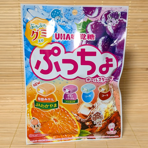 An 88g bag of UHA Mikakuto Puccho All-Star Mix featuring Arita Mikan, Nagano Purple Grape, Soda, and Cola flavors on a bamboo mat.