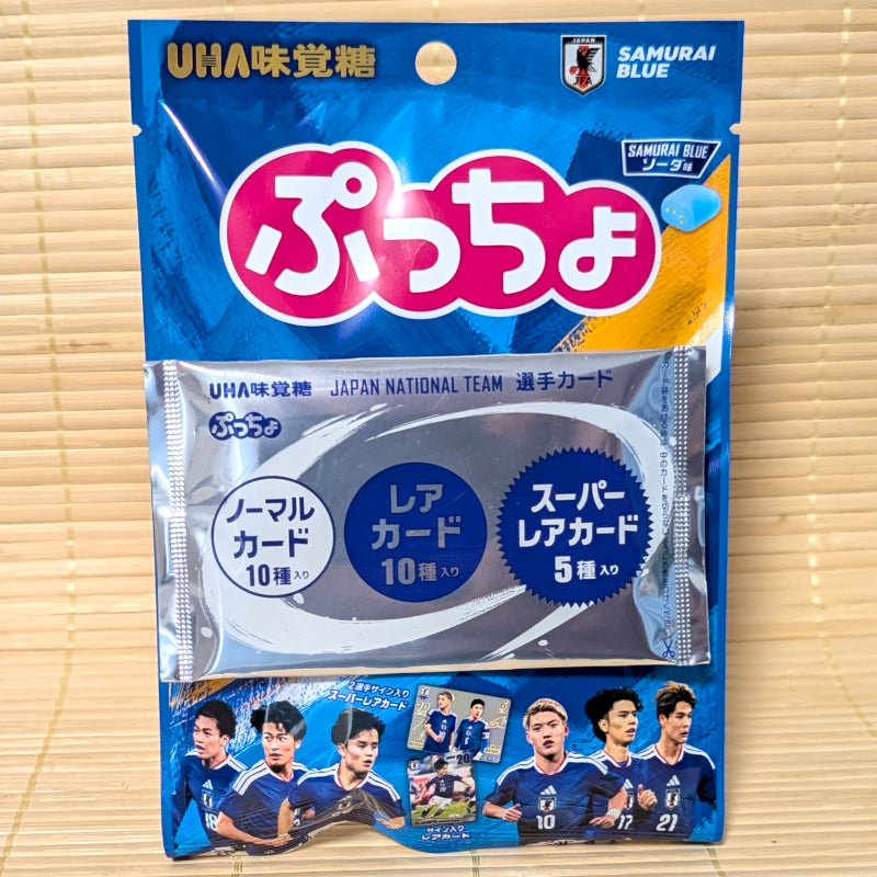 A vibrant blue pouch of UHA Puccho SAMURAI BLUE Soda candy featuring an official player trading card attached to the front package on a tatami background.
