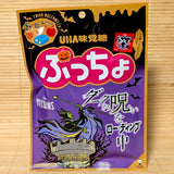 A 52g bag of UHA Mikakuto Puccho Halloween Dark Apple candy with spooky character designs on a bamboo mat.