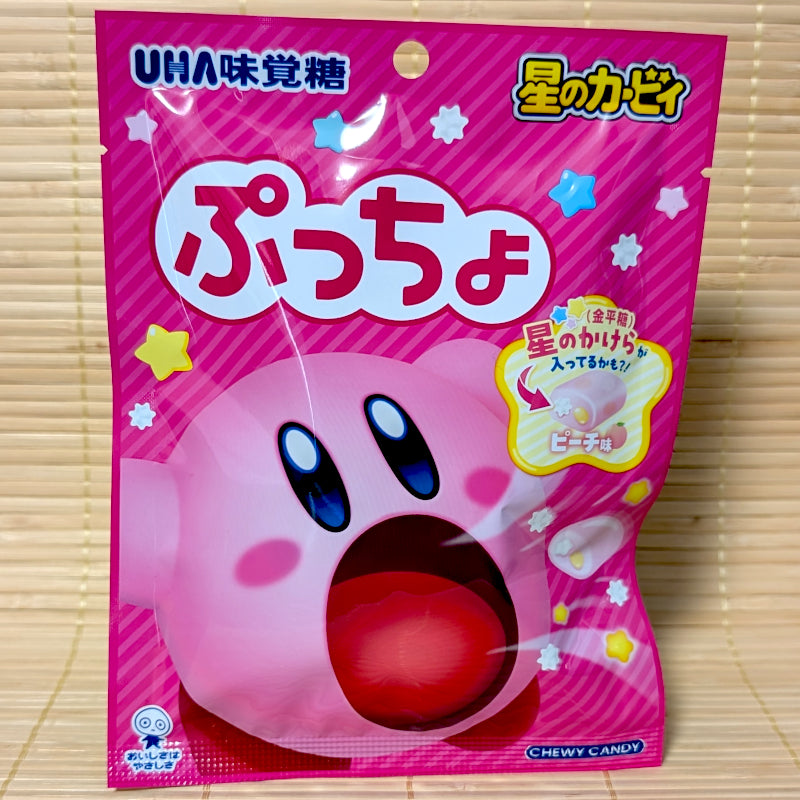 Bright pink pouch of Japanese Puccho peach soft candy featuring star-shaped candy bits. Kirby on the front panel.