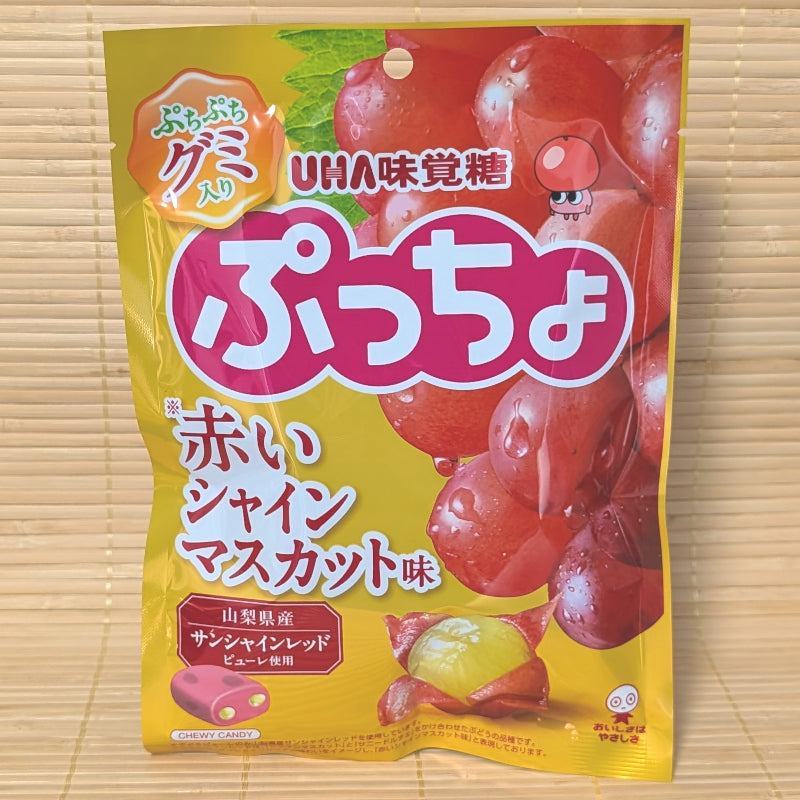 A yellow and red 72g pouch of Puccho Red Shine Muscat featuring large red grapes and a cross-section of a grape with a golden center.