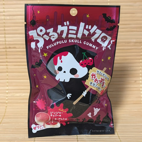 A dark magenta 40g bag of Pululu Skull Gummy showing a Reaper illustration and skull gummies on a bamboo mat.