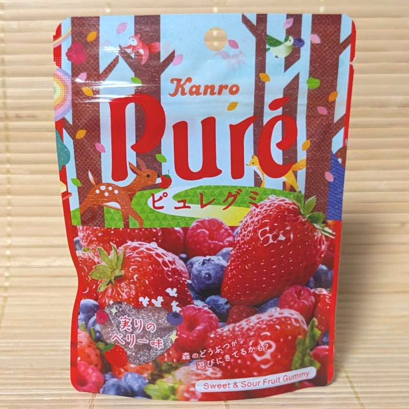 A vibrant red 52g pouch of Kanro Puré Berry Mix Gummies featuring woodland animal illustrations and fresh strawberries, raspberries, and blueberries.