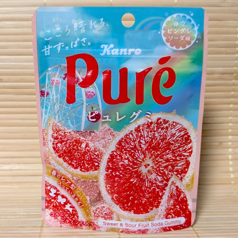 A light blue and pink resealable pouch of Kanro Pure gummies featuring large slices of pink grapefruit and a Ferris wheel in the background.