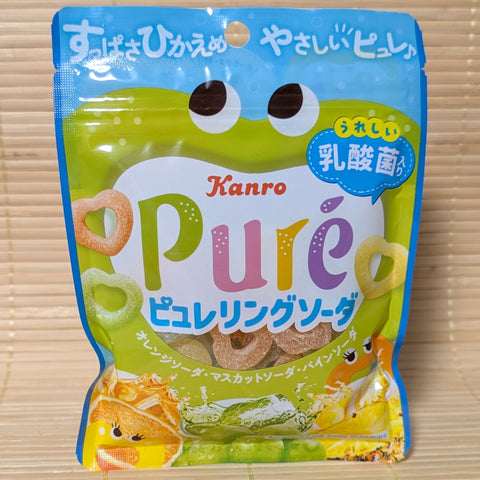A green Kanro Pure Gummy bag on a tatami background featuring a frog character and heart-shaped gummy rings.
