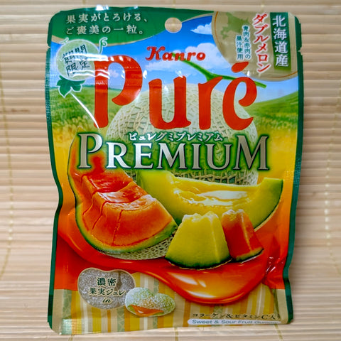 A vibrant green and orange resealable pouch of Kanro Pure Premium Hokkaido Double Melon gummies with a liquid center, on a tatami background.
